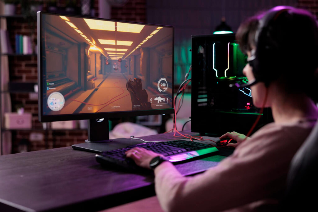 Vista de una persona que juega en la computadora, mientras viste prendas con materiales transpirables que le dan libertad de movimiento.