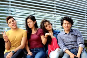 cuatro jóvenes universitarios posando de maneras divertidas para foto